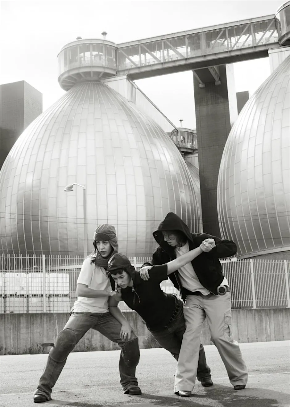 Black and white photo of three people, one of which is falling to the ground.