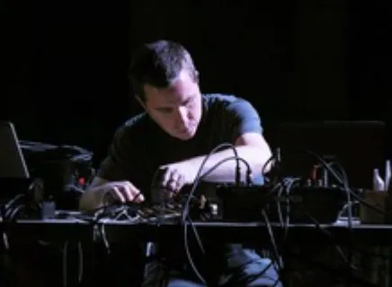 Photo of Cluett using a synthesizer