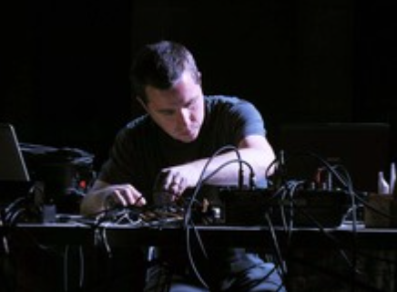 Photo of Cluett using a synthesizer