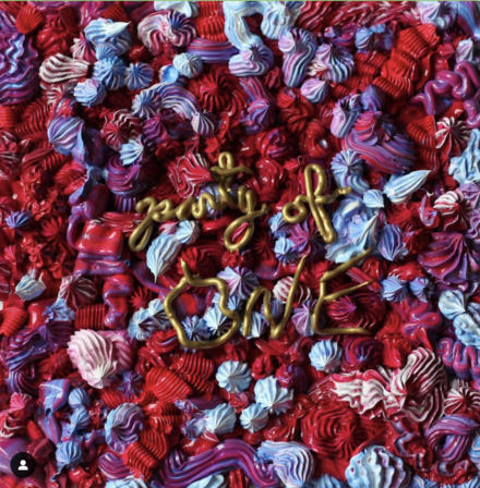 Poster for a party of one. It looks to be the name of the group made of frosting.