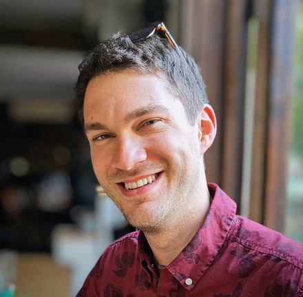Dylan Sundberg smiling in mauve shirt.